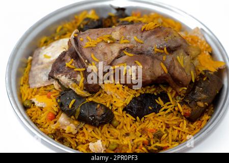 Ein gut gekochter Lammschaft mit gelbem Basmati-Reis und gemischtem Gemüse und gefüllten Traubenblättern Mahshi Mahshy mit weißem Reis, der im OV geröstet wird Stockfoto