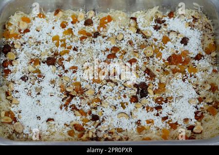 Ein traditionelles, nahöstliches Dessert Knafeh mit gesponnenem Gebäck namens Kataifi, getränkt in einem süßen, zuckerbasierten Sirup namens attar und geschichtet mit ha Stockfoto