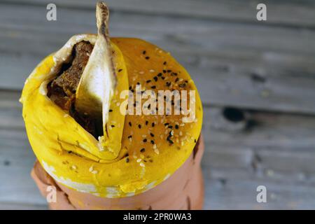 Darin befindet sich ein mit Teig, Sesam und Lammschaft bedeckter Töpferbecher mit Basmati-Reis, gemischtem Gemüse und gefüllten Traubenblättern Mahshi Ma Stockfoto