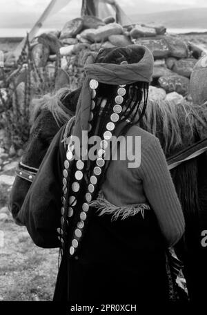 TIBETANERIN MIT ANTIKEM MÜNZHAARSTÜCK AM MANASAROVAR-SEE (4550M), BUDDHISTISCHE UND HINDUISTISCHE STÄTTE - KAILASH, TIBET Stockfoto