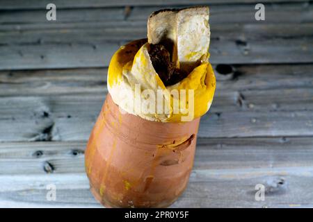 Darin befindet sich ein mit Teig, Sesam und Lammschaft bedeckter Töpferbecher mit Basmati-Reis, gemischtem Gemüse und gefüllten Traubenblättern Mahshi Ma Stockfoto