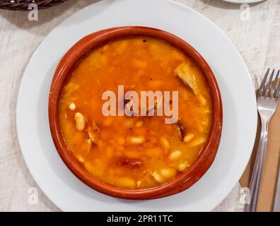 Fabada asturiana serviert in braunen Teller Stockfoto