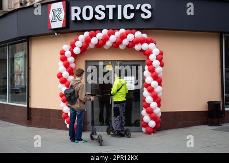 Moskau, Russland. 25. April 2023. Leute betreten ein neues Restaurant von Rostic. Das erste Restaurant unter der neuen Marke Rostic's eröffnete in Moskau an dem Ort, an dem KFC zuvor den Betrieb in Russland eingestellt hatte. Im Juli 2022 berichteten die Medien, dass Yum! Brands, Eigentümer von KFC und Pizza Hut in Russland, stellte seine Aktivitäten im Land ein und übertrug das Eigentum an einen lokalen Betreiber. Vor kurzem wurde bekannt gegeben, dass die ehemaligen KFC-Betriebe in Russland nun unter der Marke Rostic operieren werden. (Foto: Vlad Karkov/SOPA Images/Sipa USA) Guthaben: SIPA USA/Alamy Live News Stockfoto