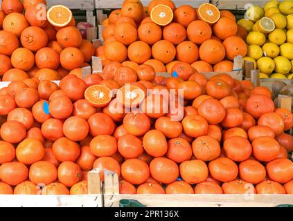 Großer Haufen Orangen, Zitronen und andere Zitrusfrüchte in Holzkisten auf dem Marktstand Stockfoto