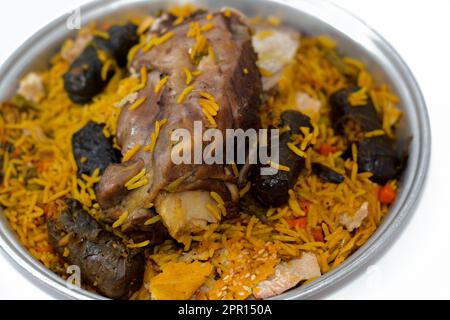 Ein gut gekochter Lammschaft mit gelbem Basmati-Reis und gemischtem Gemüse und gefüllten Traubenblättern Mahshi Mahshy mit weißem Reis, der im OV geröstet wird Stockfoto