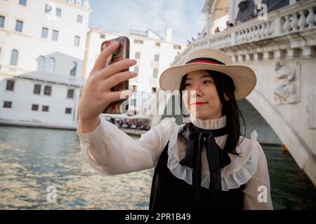 Ein chinesischer Tourist macht ein Selfie vor der Rialtobrücke in Venedig Stockfoto