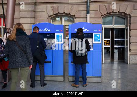 Leute, die SCNF TER-Regionalzugtickets an einem Fahrkartenautomaten am Gare de Strasbourg-Ville, Grand Est, Frankreich, kaufen. Stockfoto