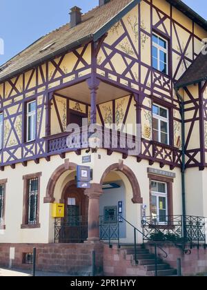 Riquewihr, Frrance - 22. September 2023: Die gelbe Fassade des Postamts in Riquewihr, Frankreich, hebt sich vom Stadtbild ab. Es ist ein täglicher Drehkreuz für Post und Pakete - ein nationaler Betreiber der La Poste Banque. Stockfoto