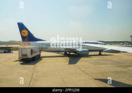 Deutschland – 6. Juli 2015: Eine Lufthansa Boeing 737-MSN 25149 trifft auf einer Start- und Landebahn ein, deren Schatten auf der Rollbahn erscheint, als ein Lkw von SkyChefs auf ihr Ziel in Deutschland entladen und verladen wird. Stockfoto