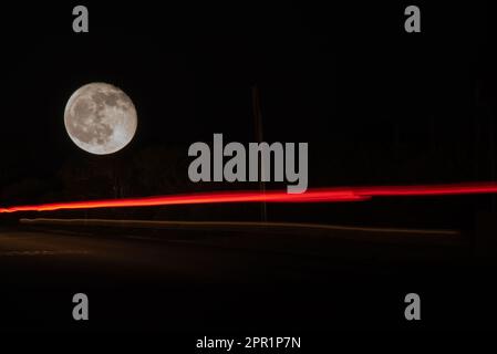 Linien eines Fahrzeugs auf der Straße nach Sancti Petri beleuchtet vom fast Vollmond. Stockfoto