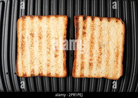 Moderner Sandwichmaker mit Brotscheiben, Draufsicht Stockfoto