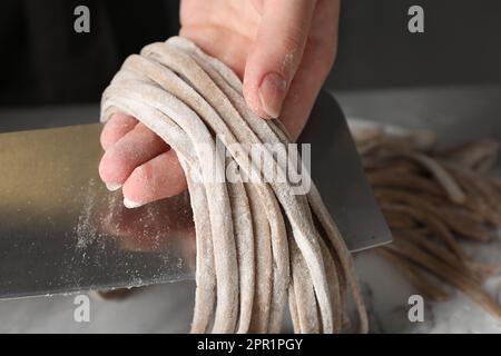 Frau, die Soba (Buchweizennudeln) am Tisch macht, Nahaufnahme Stockfoto