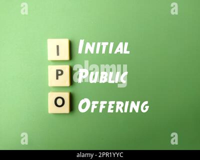 Top-View-Spielzeugwort mit dem Wort „IPO Initial Public Offer“ auf grünem Hintergrund Stockfoto