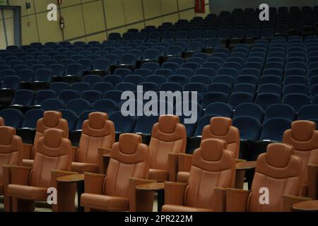 Riesige und luxuriöse Universitäts-Auditorium-Stühle. Blaue und braune Theaterstühle. Stockfoto