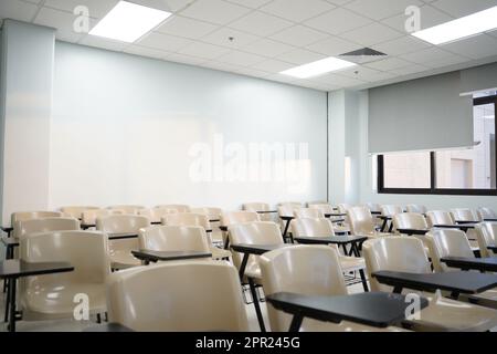 Leere Kurse an der Universität oder Schule mit Stühlen und Beistelltischen, die Stühle sind in Reihen angeordnet. Stockfoto