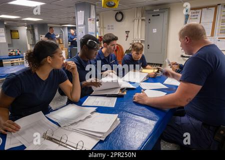 Besatzungsmitglieder an Bord von Coast Guard Cutter Midgett (WMSL 757) gehen die Standards durch, die erforderlich sind, um geschultes und qualifiziertes Personal an Bord des Cutters, Pazifik, am 24. Februar 2023 zu werden. Die Besatzungen der Küstenwache trainieren, um auf eine Vielzahl von Situationen bei allen Wetterbedingungen zu reagieren. (Küstenwache Foto von Petty Officer 3. Klasse Briana Carter) Stockfoto