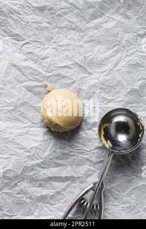 Schaufeln mit Vanille-Keksteig auf einem mit Pergament ausgekleideten Keksblatt, einfacher Vanille-Keksteig, der gleich gebacken wird Stockfoto