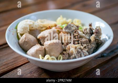 Eine Schüssel Fleischkugelsuppe mit frischem Gemüse auf dem alten Holztisch Stockfoto