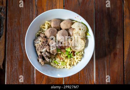 Eine Schüssel Fleischkugelsuppe mit frischem Gemüse auf dem alten Holztisch Stockfoto