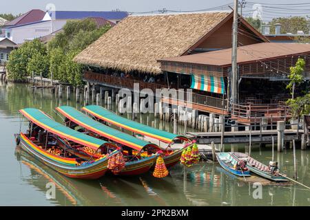 Traditionelle hölzerne Boote mit Blumen auf der Nase sind am Anleger in Thailand verankert Stockfoto