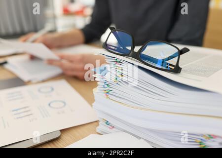 Brillen für das Sehvermögen liegen auf einem Stapel von Dokumenten am Arbeitsplatz Stockfoto