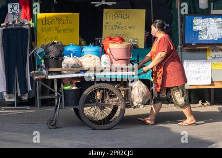 SAMUT PRAKAN, THAILAND, APR 07 2023, Eine Frau schiebt einen Wagen mit Eimern auf dem Marktplatz Stockfoto