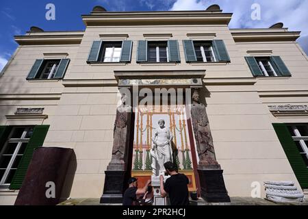 Berlin, Deutschland. 24. April 2023. Die Marmorskulptur des griechischen gottes des heilenden Asklepios befindet sich wieder an der Ostfassade des Casinos im Glienicke Palace Park zwischen zwei Kariatiden (Skulpturen von Frauen anstelle einer Säule) und wird von zwei Restauratoren repariert. Mit der Restaurierung der Skulptur, antiker Säulenteile und eines Wandbildes konnte die Stiftung Preußische Paläste und Gärten Berlin-Brandenburg (SPSG) die Restaurierung des Bank-Ensembles im Kasino in den Gärten des Schlosses Glienicke abschließen. Kredit: Soeren Stache/dpa/Alamy Live News Stockfoto