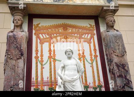 Berlin, Deutschland. 24. April 2023. Die Marmorskulptur des griechischen gottes des heilenden Asklepios befindet sich wieder an der Ostfassade des Casinos im Glienicke Palace Park zwischen zwei Kariatiden (Skulpturen von Frauen anstelle einer Säule) und wird von zwei Restauratoren repariert. Mit der Restaurierung der Skulptur, antiker Säulenteile und eines Wandbildes konnte die Stiftung Preußische Paläste und Gärten Berlin-Brandenburg (SPSG) die Restaurierung des Bank-Ensembles im Kasino in den Gärten des Schlosses Glienicke abschließen. Kredit: Soeren Stache/dpa/Alamy Live News Stockfoto