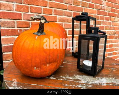 Kürbisse rustikale Heudekoration im Freien. Stilvolles Herbstdekor des Außengebäudes. Ländliche Einrichtung auf Heuhaufen in der Straße. Herbsternte Thanksgiving und Halloween Feiertagsvorbereitungen. Stockfoto