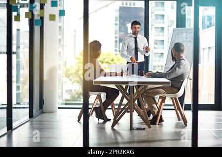 Sprechen wir über Produktivität. Eine Gruppe von Kollegen, die ein Meeting in einem modernen Büro abhalten. Stockfoto