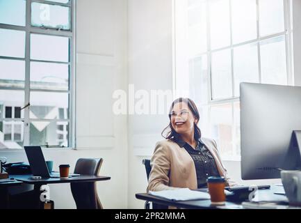 Träumen Sie immer von den großartigen Dingen, die Sie erreichen können. Eine junge Geschäftsfrau, die an einem Computer in einem Büro arbeitet. Stockfoto