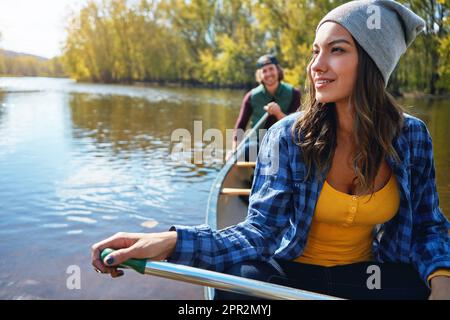Wasserliebhaber tun, was sie am besten können. Ein junges Paar, das eine Kanufahrt auf dem See macht. Stockfoto