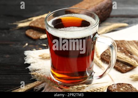 Tasse mit köstlichem KWass, Stacheln und Brot auf dem Tisch Stockfoto