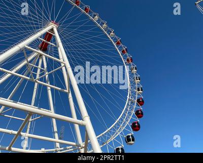 Riesenrad-gelb mit mehrfarbigen Kabinen. Stockfoto