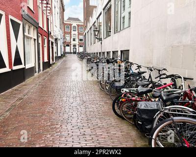 Viele geparkte Fahrräder in der Nähe des Gebäudes an der Stadtstraße Stockfoto