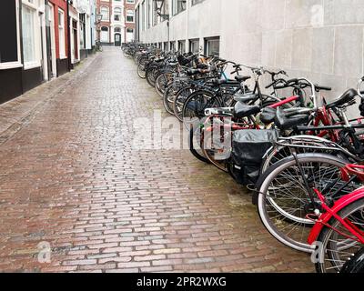 Viele geparkte Fahrräder in der Nähe des Gebäudes an der Stadtstraße Stockfoto