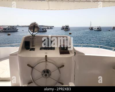 Die Kabine des Captains auf einem Schiff, Boot, Kreuzfahrtschiff mit Lenkrad, Armaturenbrett, Navigator, Kompass und Steuergeräten vor dem Hintergrund o Stockfoto