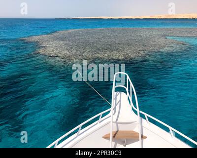 Die Nase, die Vorderseite der weißen Yacht, das Boot, das Schiff, das auf dem Jig steht, Parken, Anker im Meer, das Meer mit blauem Wasser mit Korallen Stockfoto