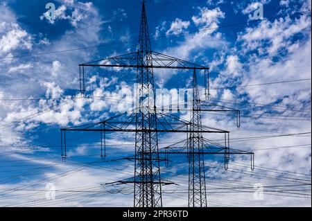 Elektrische Hochspannungsmasten gegen den Himmel mit dramatischen Wolken Stockfoto