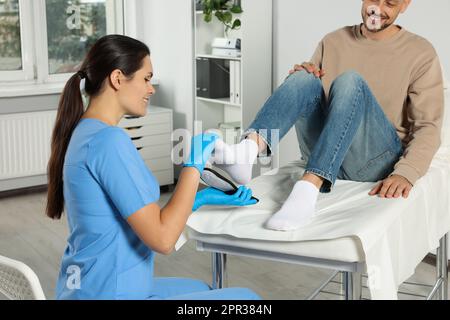 Schöne Orthopädin-Einlegesohle am Fuss des Patienten im Krankenhaus Stockfoto