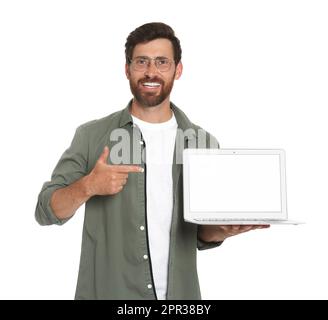 Ein hübscher Mann, der auf einen Laptop auf weißem Hintergrund zeigt Stockfoto