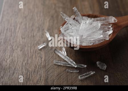 Menthol-Kristalle auf Holzhintergrund, Nahaufnahme. Platz für Text Stockfoto