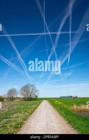 Landstraße unter einem Himmel voller Dampfpfade Stockfoto