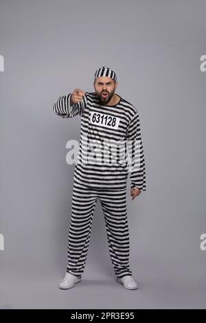 Emotionaler Gefangener in Spezialuniform auf grauem Hintergrund Stockfoto