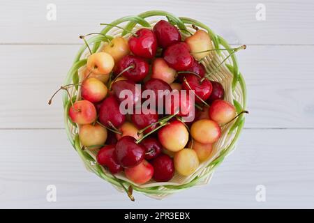 Kirschen in einem Korb auf dem Tisch. Reife süße, köstliche Kirschen in einem Korb aus Korb aus Korb. Sommerbeeren aus der Nahaufnahme. Vegetarisches Essen, gesunde Früchte von der Stockfoto