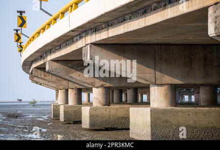Struktur der Stahlbetonbrücke entlang des Meeres. Untersicht der Betonbrücke. Betonbrückenbau. Moderne Zementbrücke Stockfoto