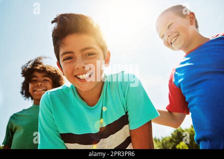 Die besten Tage verbringen wir mit meinen Jungs. Porträt einer Gruppe von vielfältigen und glücklichen Kindern, die an einem hellen Tag draußen zusammen abhängen. Stockfoto