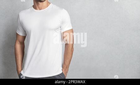 Sportlicher Mann mit weißem T-Shirt auf grauem Hintergrund. Vorlage oder Modell für Bekleidungsdesign Stockfoto