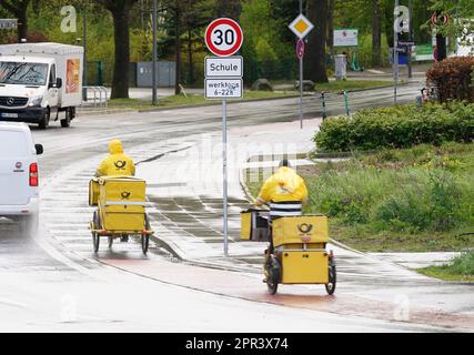 Hamburg, Deutschland. 26. April 2023. Briefträger machen ihre Runden auf ihren Firmenfahrrädern. Kredit: Marcus Brandt/dpa/Alamy Live News Stockfoto