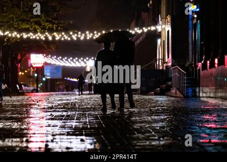 Zusammen Unter Dem Schirm. Zwei Menschen unter einem Schirm, ein Mann und eine Frau laufen in einer Stadt mit einem Schirm, laufen im Regen, im Herbst Stockfoto